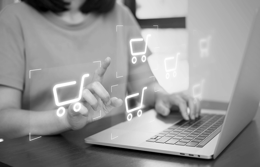 person working on her laptop and tapping digital shopping bags