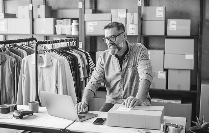 guy working in a fashion shop, packages in the back