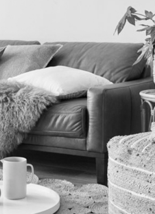 cozy living room with a leather couch and a pouf