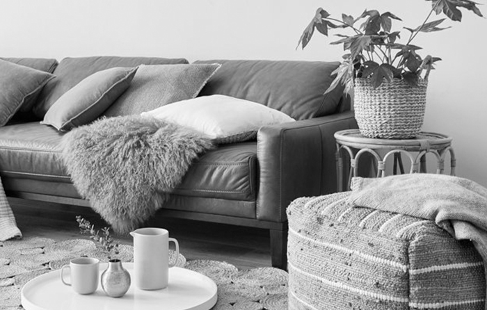 cozy living room with a leather couch and a pouf